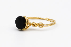 Picture of the Kira ring, a Nelumbo jewelry piece, handmade from 14k solid gold and black tourmaline